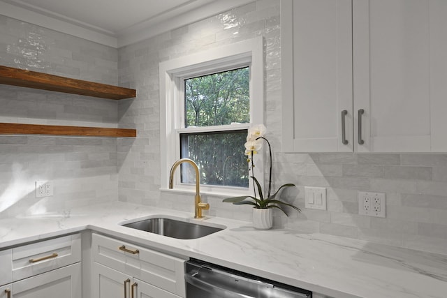 kitchen featuring white cabinets, decorative backsplash, a sink, and dishwasher