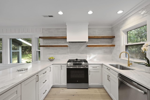 kitchen featuring visible vents, open shelves, light stone counters, a sink, and stainless steel appliances