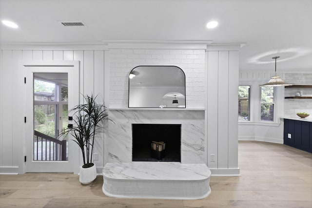 interior details featuring a high end fireplace, baseboards, wood finished floors, and visible vents