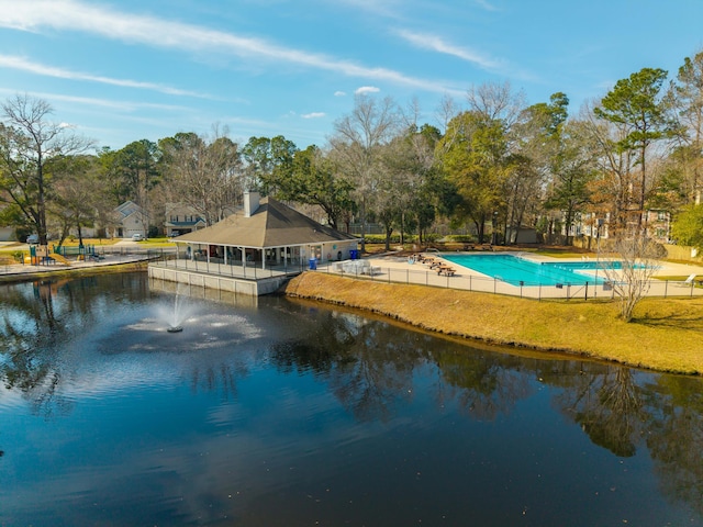 exterior space with a lawn, a water view, and fence