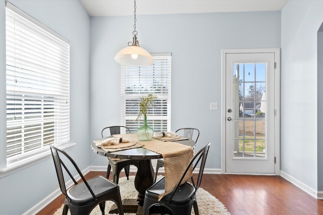 dining space with baseboards and dark wood-type flooring