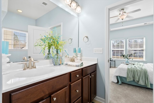 full bath with a ceiling fan, visible vents, double vanity, a sink, and connected bathroom