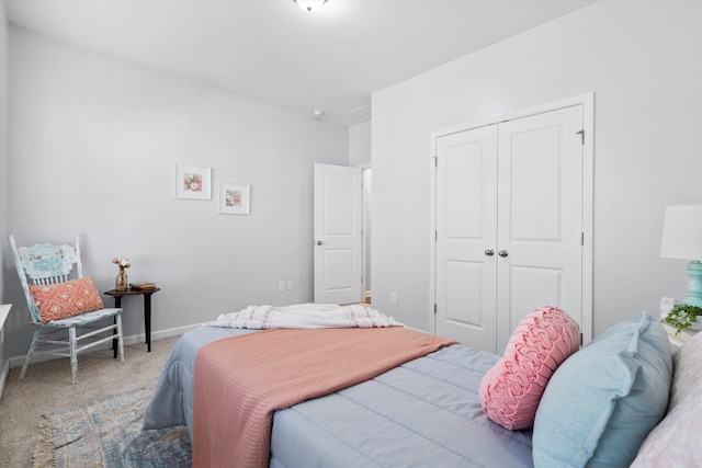 carpeted bedroom featuring a closet and baseboards