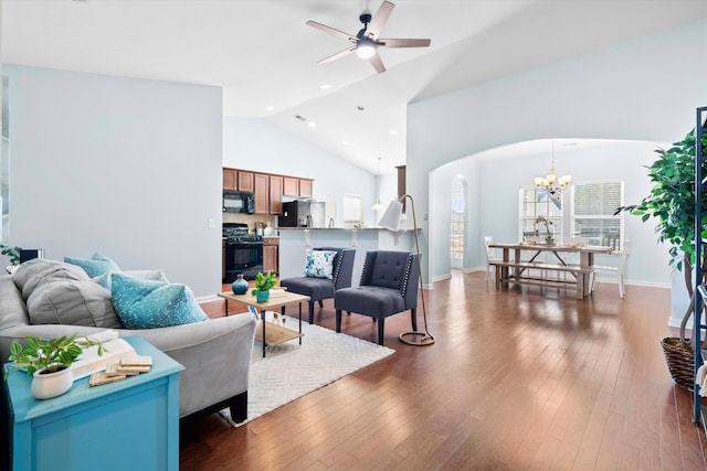 living area with baseboards, ceiling fan with notable chandelier, arched walkways, dark wood-style floors, and high vaulted ceiling