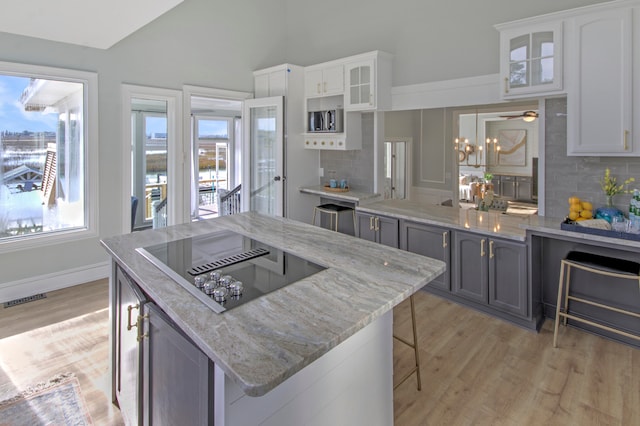 kitchen with light hardwood / wood-style floors, white cabinets, and tasteful backsplash