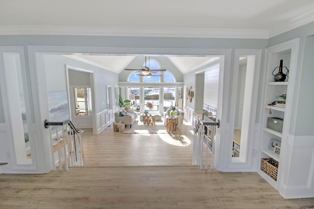 interior space with ornamental molding, a chandelier, vaulted ceiling, and light hardwood / wood-style flooring