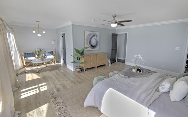 bedroom featuring crown molding, ceiling fan with notable chandelier, and light hardwood / wood-style floors