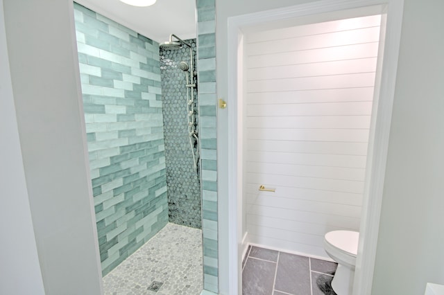 bathroom featuring toilet, tile floors, and tiled shower