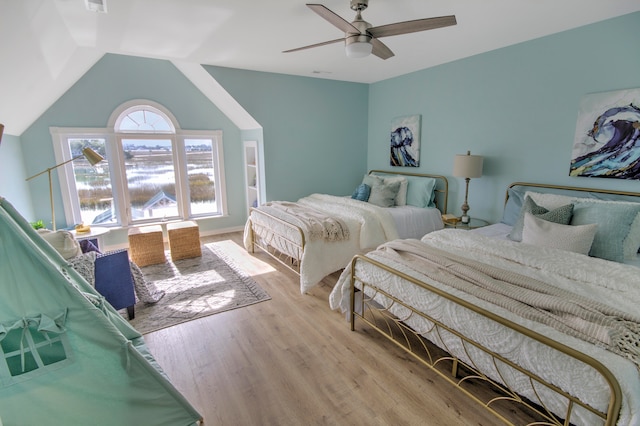 bedroom featuring ceiling fan, light wood-type flooring, and vaulted ceiling