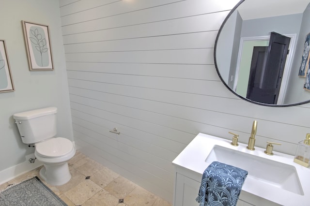 bathroom with toilet, vanity, and tile flooring