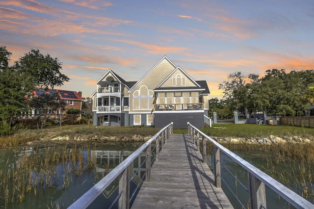 view of dock with a balcony and a water view