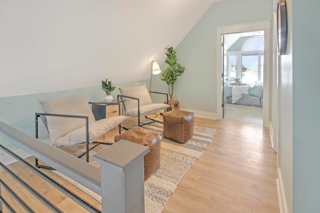 living area featuring vaulted ceiling and light hardwood / wood-style floors