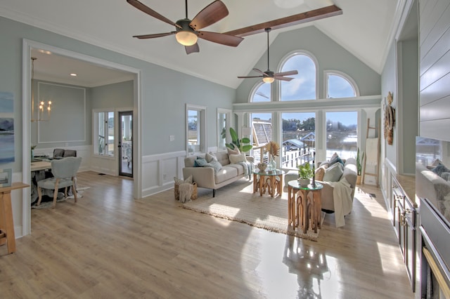 living room with crown molding, high vaulted ceiling, ceiling fan with notable chandelier, and light hardwood / wood-style flooring