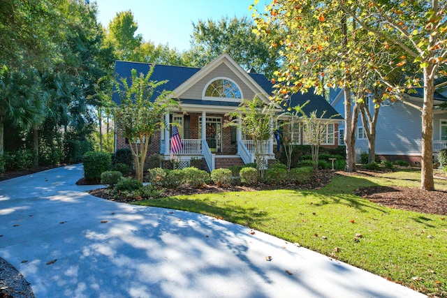 view of front of home featuring covered porch and a front lawn