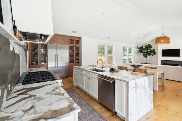 kitchen featuring white cabinetry, appliances with stainless steel finishes, sink, and a center island with sink