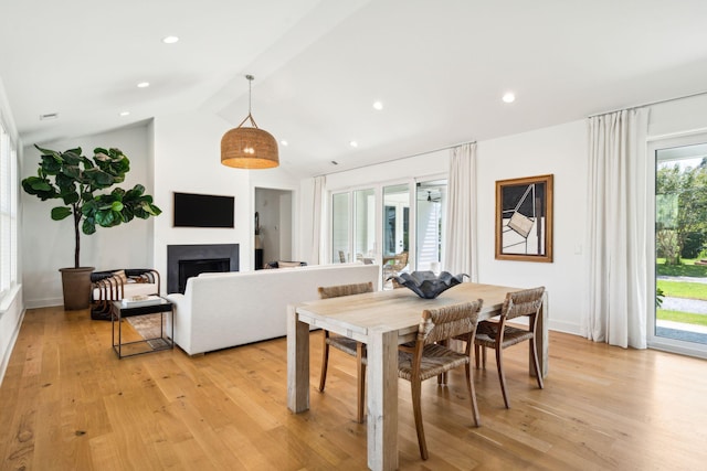 dining room with lofted ceiling and light hardwood / wood-style floors