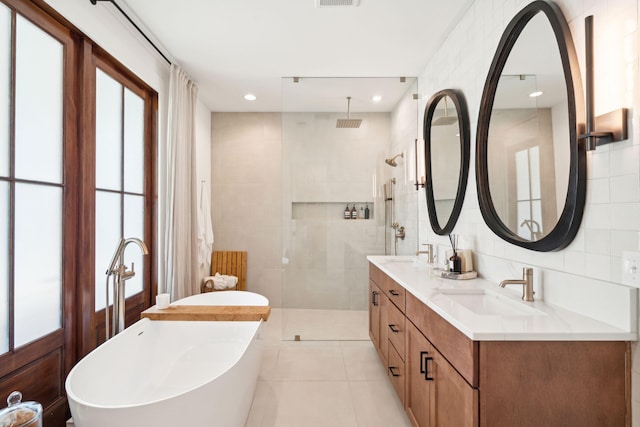 bathroom with tile walls, tile patterned flooring, and shower with separate bathtub