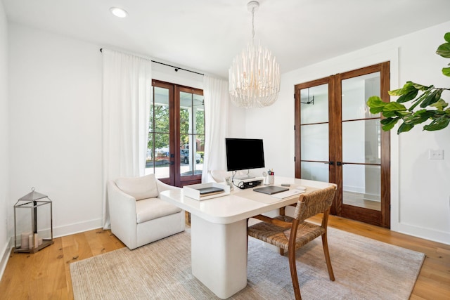 office space featuring french doors, light hardwood / wood-style floors, and a notable chandelier