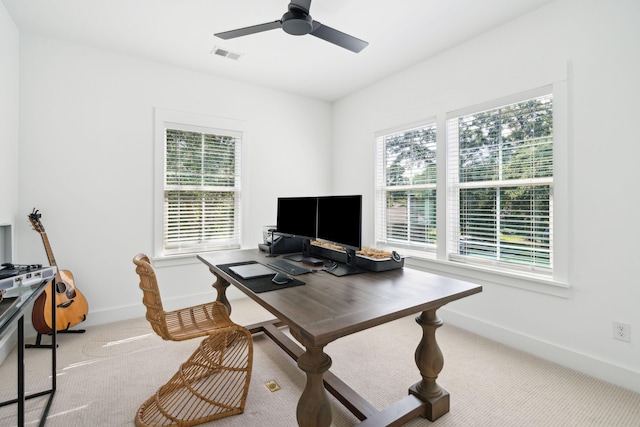 carpeted home office with ceiling fan and a healthy amount of sunlight