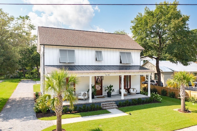 modern farmhouse style home featuring a front yard and covered porch