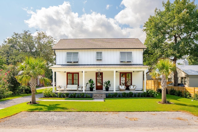 modern farmhouse style home featuring a front lawn, french doors, and a porch