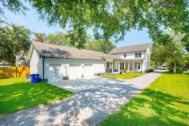 view of front of property featuring a garage, covered porch, and a front lawn