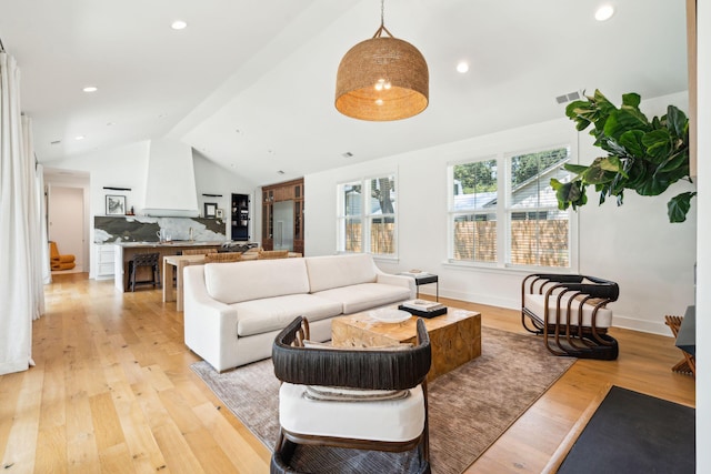 living room with lofted ceiling and light hardwood / wood-style flooring