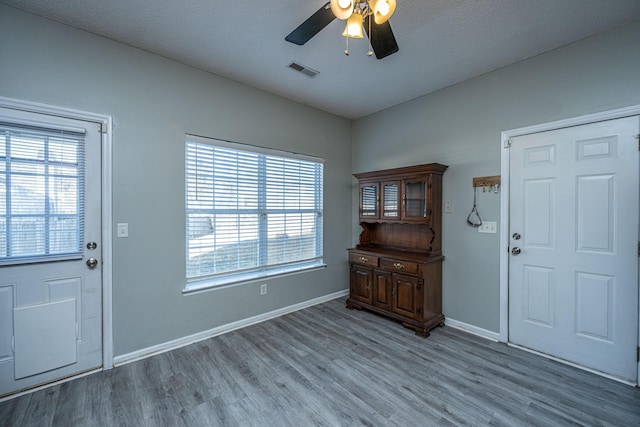 entryway with ceiling fan, a textured ceiling, and light wood-type flooring