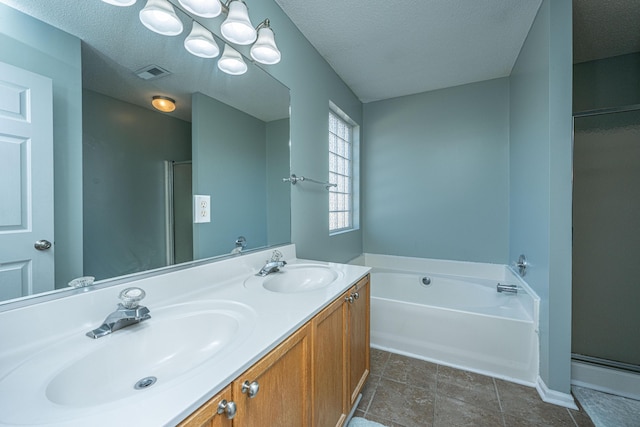 bathroom with vanity, shower with separate bathtub, and a textured ceiling