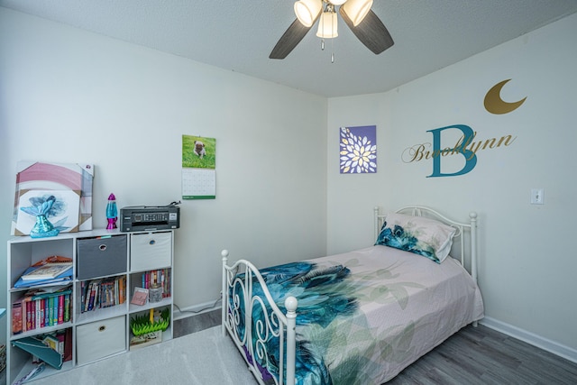 bedroom with a textured ceiling, dark hardwood / wood-style floors, and ceiling fan