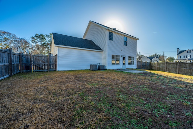 rear view of house featuring cooling unit, a patio area, and a lawn