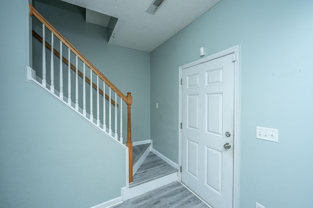 entrance foyer with a textured ceiling and light wood-type flooring