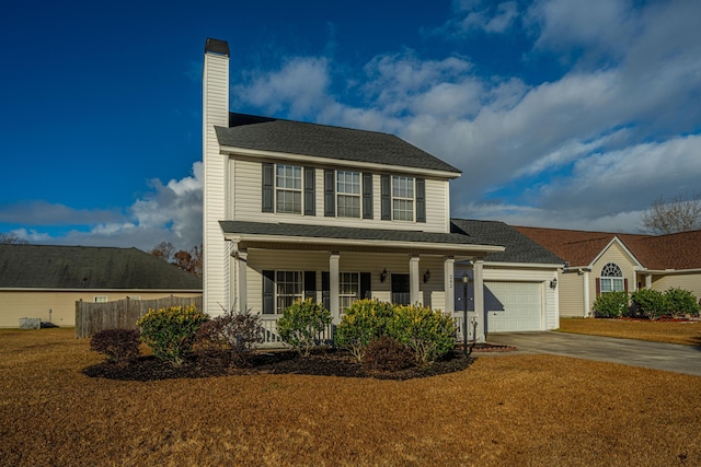 view of front of home featuring a garage, a front yard, and covered porch