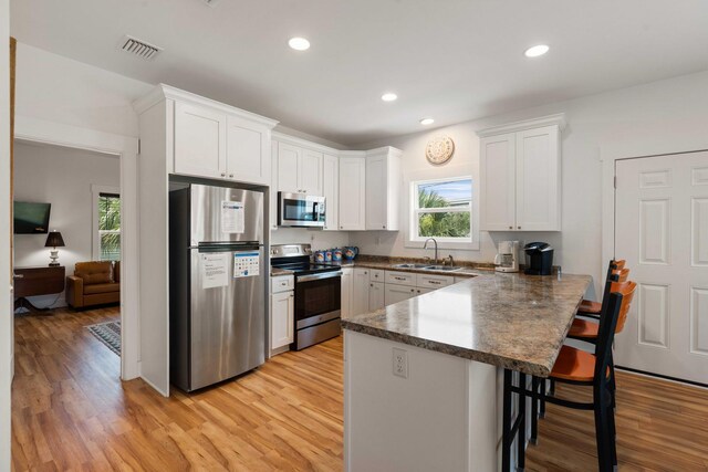 31 W 9th St, Folly Beach, SC 29439 - kitchen featuring appliances with stainless steel finishes, a peninsula, plenty of natural light, a breakfast bar, and recessed lighting