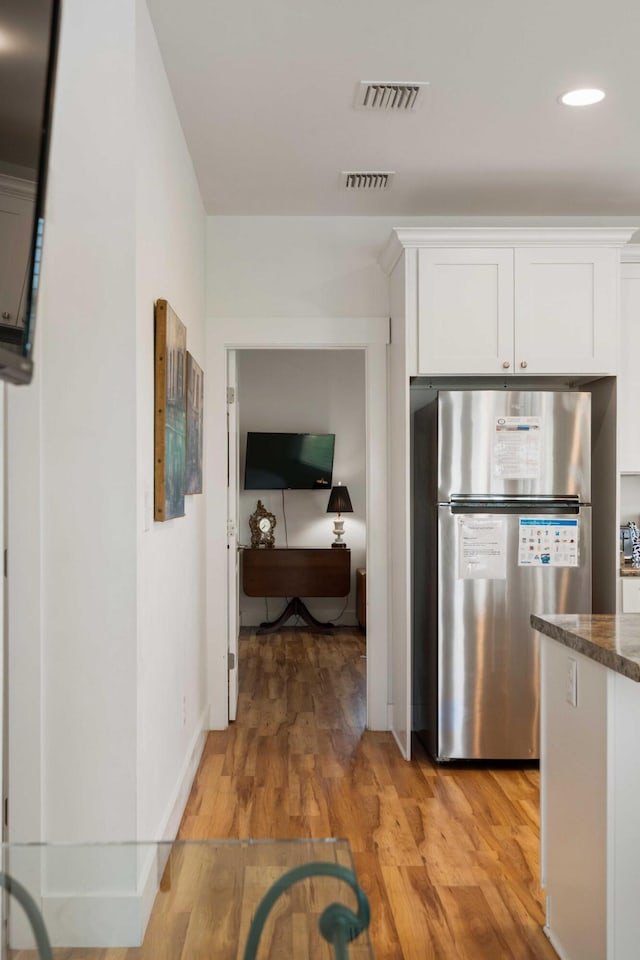 31 W 9th St, Folly Beach, SC 29439 - kitchen featuring freestanding refrigerator, white cabinetry, light wood finished floors, recessed lighting, and dark stone countertops