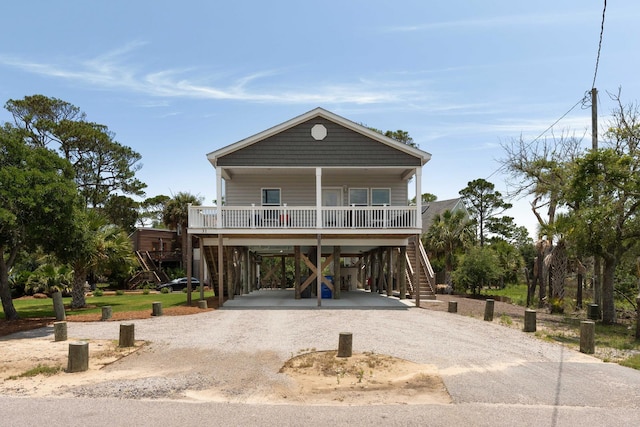 31 W 9th St, Folly Beach, SC 29439 - raised beach house with a porch, a carport, stairs, and driveway