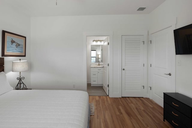 31 W 9th St, Folly Beach, SC 29439 - bedroom with wood finished floors, a closet, and connected bathroom