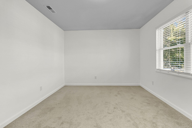 empty room featuring carpet, visible vents, and baseboards