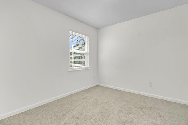 carpeted spare room featuring baseboards