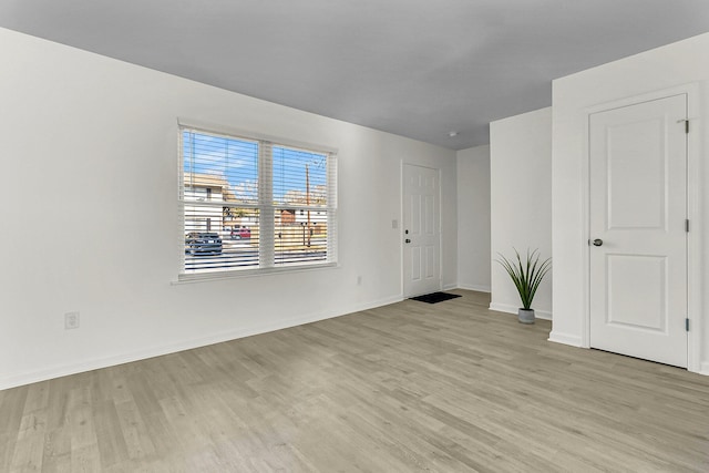 interior space featuring light wood-type flooring and baseboards