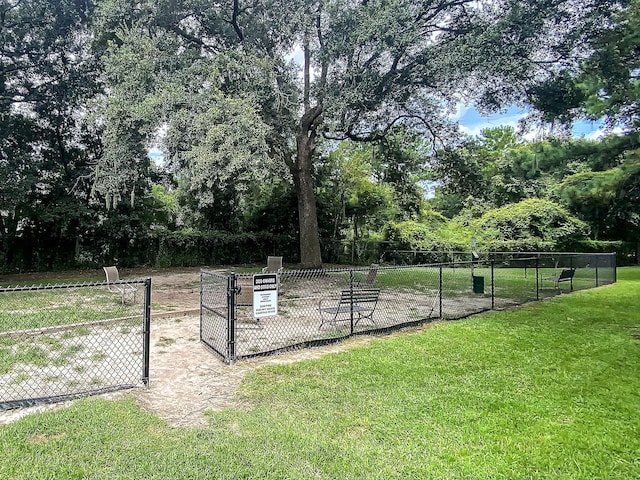 view of community featuring a gate, a lawn, and fence