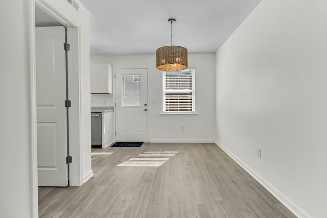 unfurnished dining area with visible vents, baseboards, and light wood finished floors