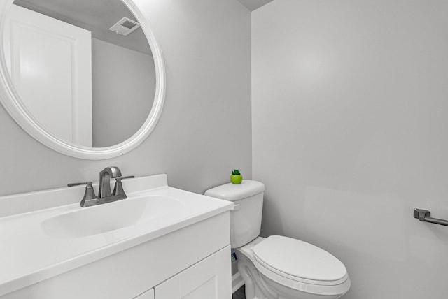 half bathroom with visible vents, toilet, and vanity