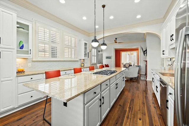 kitchen featuring white cabinetry, crown molding, a center island, and hanging light fixtures