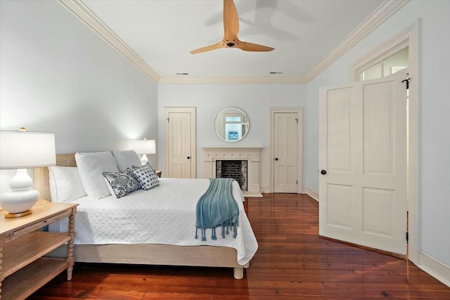 bedroom featuring dark wood-type flooring, ornamental molding, and ceiling fan