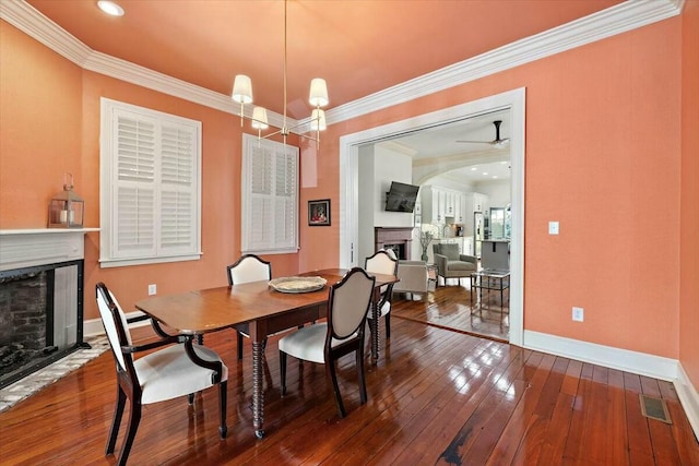 dining space with ornamental molding, hardwood / wood-style floors, and an inviting chandelier