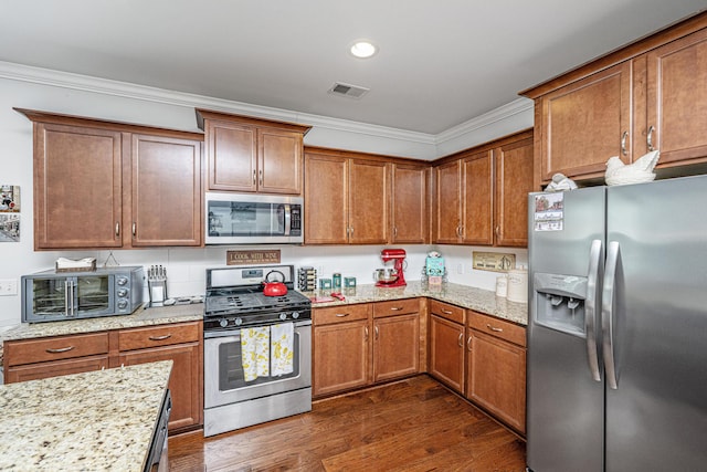 5442 Clearview Dr, North Charleston, SC 29420 - kitchen featuring appliances with stainless steel finishes, ornamental molding, dark wood-type flooring, brown cabinets, and light stone countertops
