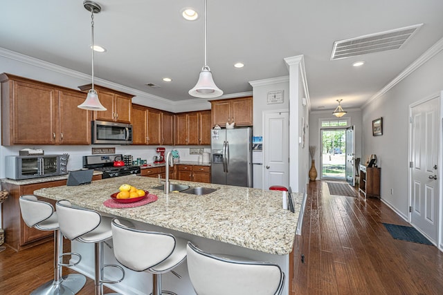 5442 Clearview Dr, North Charleston, SC 29420 - kitchen featuring stainless steel appliances, a sink, brown cabinetry, crown molding, and an island with sink