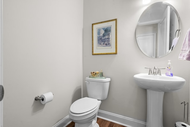 bathroom with hardwood / wood-style flooring and toilet