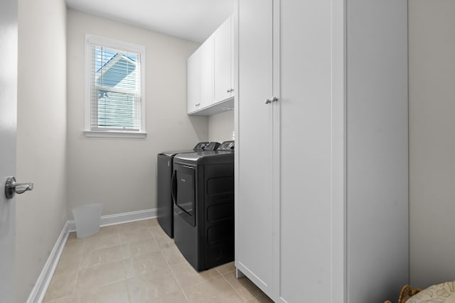 laundry area with light tile patterned flooring, cabinets, and washer and dryer